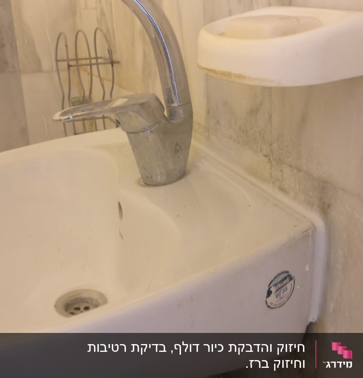 כיור עם ברז מתכת בחדר אמבטיה